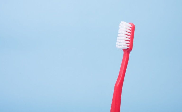 red toothbrush on blue background